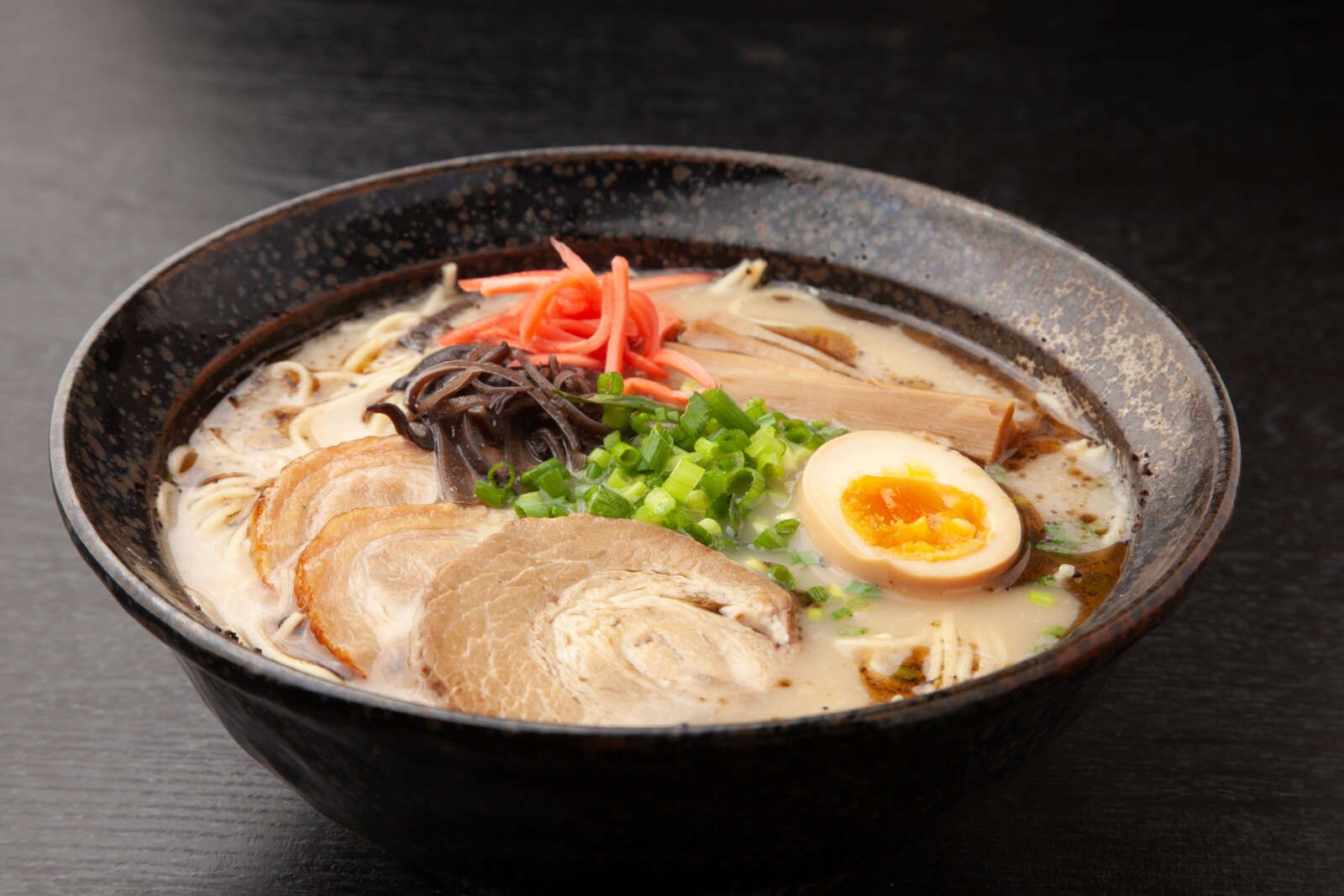 熊本ラーメンとは、豚骨ベースのスープに「焦がしニンニク（マー油）」や「ニンニクチップ」を効かせた、熊本県を代表するご当地ラーメン！