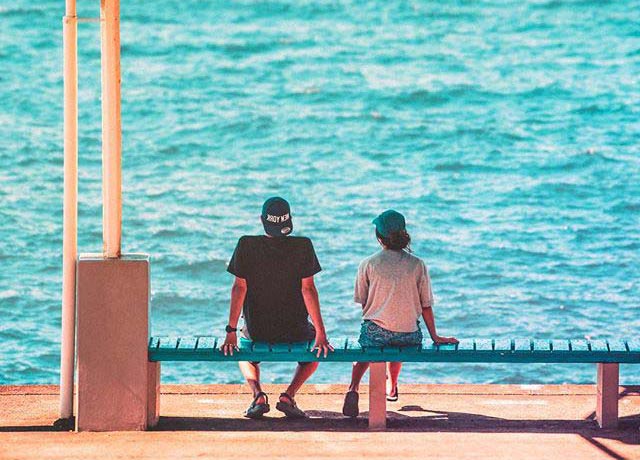 海辺に座る二人の写真